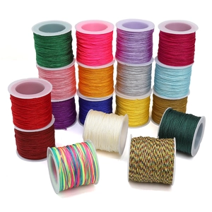 Detailed macro view of 18 colorful 0.8mm nylon braiding cords on white spools