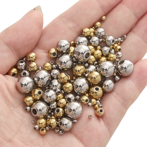 Close-up of gold and silver stainless steel spacer beads held in a hand for jewelry DIY