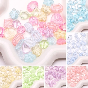 Detailed close-up of mixed macaron acrylic beads in various shapes and floral patterns