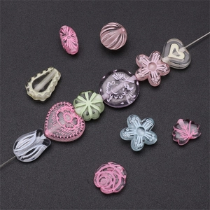 Macro view of pastel acrylic beads in heart, flower, and leaf shapes for DIY jewelry