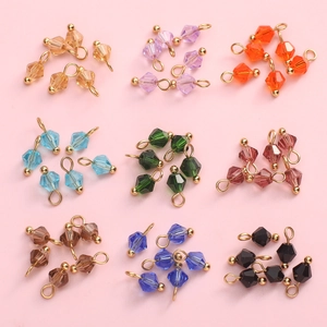 Close-up of 4mm faceted glass bead charms in assorted colors with gold rings for DIY jewelry