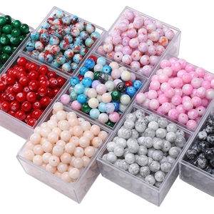 Primer plano de cuentas de vidrio veteadas de colores en caja para joyería artesanal