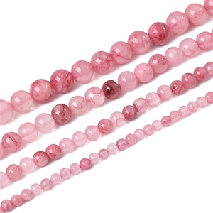 Dettaglio di perline di giada persiana sintetica rosa in quattro dimensioni per gioielli fai-da-te