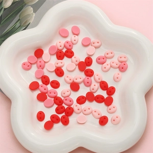 Macro shot of pink acrylic pig nose charms in a white dish for DIY handmade accessories
