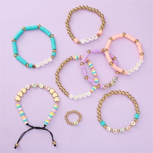 Detail view of 6 colorful clay bead bracelets and 1 ring set with gold metal accents