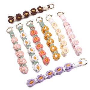 Detailed view of woven daisy keychains in eight colors with golden spring buckles