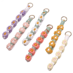 Detail of colorful macrame daisy keychains with premium gold round snap hooks
