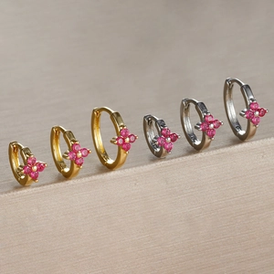 Detail shot of four-leaf clover earrings with red zircons in gold and silver plating