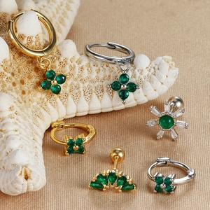 Three-piece gold-toned earring set with emerald green crystals and clover-shaped floral designs