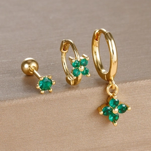 Macro detail of gold-plated clover earrings set with emerald green zircon stones
