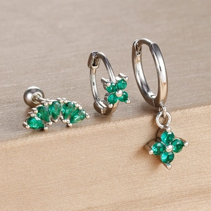 Detailed macro view of three-piece silver-plated emerald green clover earring set