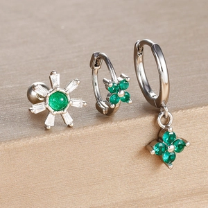 Detailed macro view of silver clover earring set with emerald green cubic zirconia stones