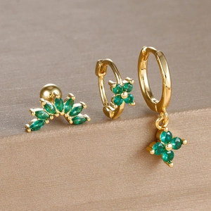 Detailed view of three-piece gold earring set with vibrant green zircon four-leaf clover charms