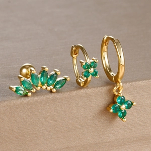 Detailed set of gold earrings with green clover stones and marquise gems on display