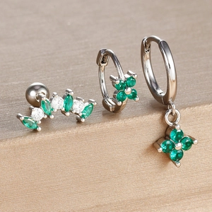 Detail of silver clover earrings set featuring emerald green stones and zircon accents