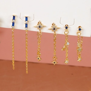 Detail of elegant gold tassel earrings set with blue zircon stars and sleek chains