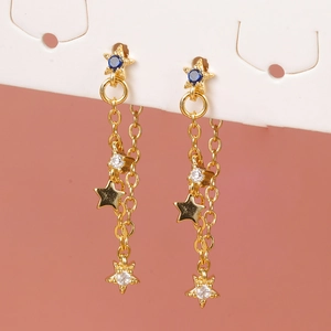 Macro shot of gold star tassel earrings featuring sparkling blue and white zircon stones