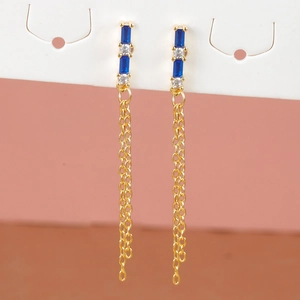 Detail of gold star earrings with blue crystals and long chain tassels on white card