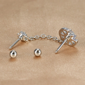 Détail de la boucle d'oreille double piercing en acier argenté avec clou étoile et chaîne