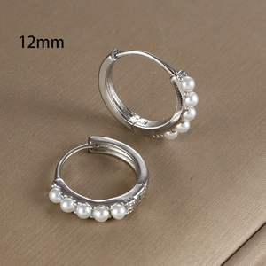Dettaglio di orecchini a cerchio argento da 12 mm con cinque perle bianche incastonate