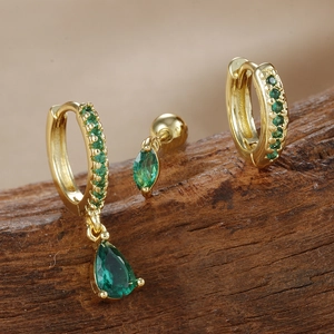 Detalle del set de pendientes de oro y circón esmeralda con colgante de gota y botón