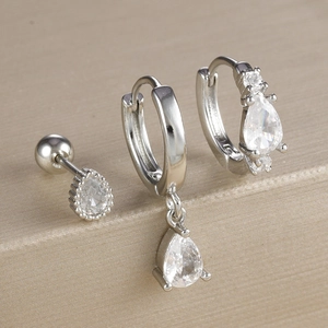 Vue macro de l'ensemble de trois boucles d'oreilles goutte en zircon sur socle beige