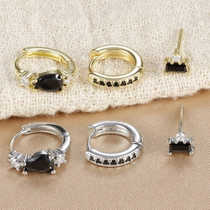 Dettaglio dei set di orecchini in oro e argento con pietre nere e zirconi scintillanti