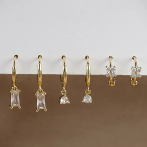 Detailed macro view of gold plated earrings featuring zircon flower and butterfly designs