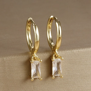 Macro shot of gold-plated hoop earrings with rectangular cubic zirconia in a 4-prong setting
