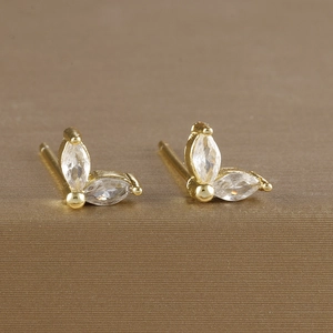 Macro detail of gold plated flower stud earrings with marquise cut zircon stones