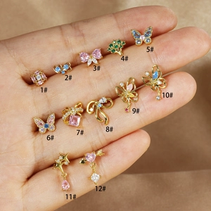 Macro detail of twelve gold-plated bow and butterfly cartilage studs with zircon in hand