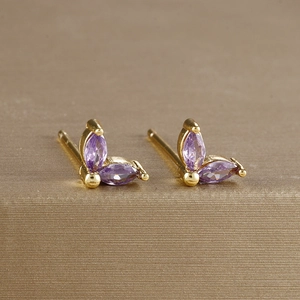 Detailed macro view of purple zircon flower earrings set in gold plated brass material