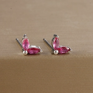 Close-up of pink marquise zircon butterfly stud earrings on a golden stand