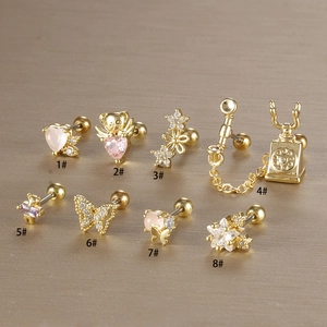 Dettaglio di 8 piercing per cartilagine dorati con farfalla in zircone e vari motivi a cuore