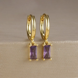 Dettaglio di orecchini in ottone dorato con zircone viola quadrato e frangia a catena