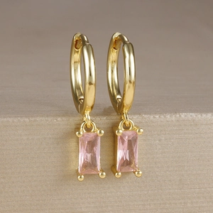 Dettaglio di orecchini a cerchio placcati in oro con eleganti pendenti in zircone rosa rettangolari