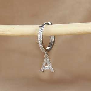 Macro detail of silver letter A earring with micro-pave cubic zirconia crystals