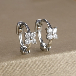 Detail of silver clover earrings with cubic zirconia and a snap closure mechanism