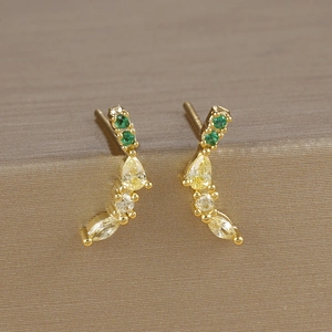 Close-up of gold stud earrings with elegant curved lines and colorful zircon gemstones