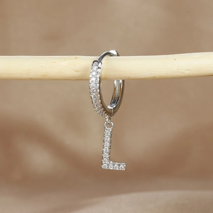 Detailed view of silver hoop earring with micro-paved zircon letter L pendant