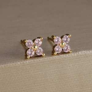 Dettaglio macro di orecchini a lobo placcati oro con fiori in zircone rosa