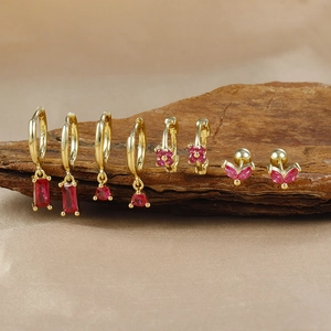 Detailed view of four pairs of gold-plated S925 earrings with red zircon stones