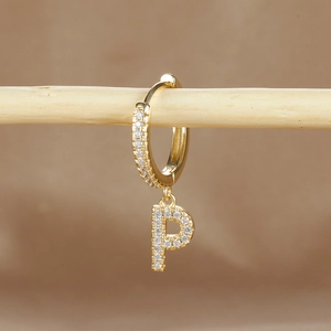 Macro shot of gold-plated P-letter earring with micro-pave cubic zirconia inlay