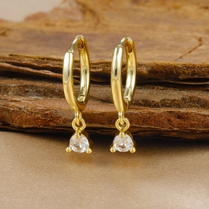 Macro view of gold plated brass earrings featuring round clear cubic zirconia stones