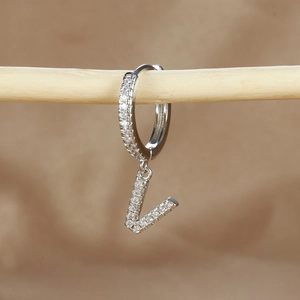 Macro detail of silver letter L pendant earring with micro-paved cubic zirconia