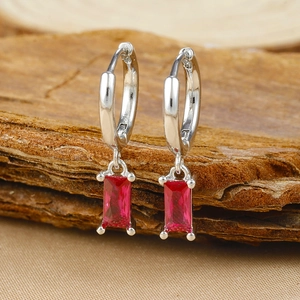 Detail of silver-plated brass earrings featuring rectangular red zircon pendant charms