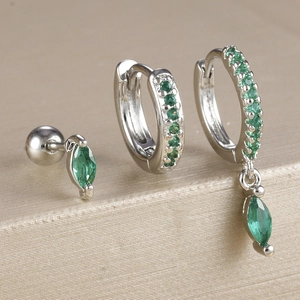 Vue macro d'un ensemble de trois boucles d'oreilles en argent avec zircons verts