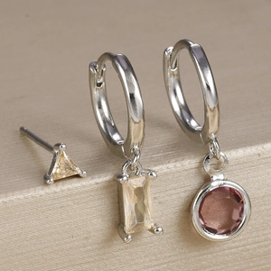 Macro detail of geometric silver zircon earrings set with champagne and pink crystals