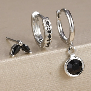 Detail shot of silver earrings set with micro-paved black zircon stones and studs