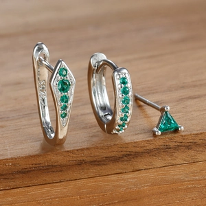 Makroaufnahme von S925 Sterlingsilber-Ohrringen mit grünem Zirkon auf Holzdekor